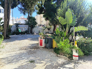 a shaded car park with a gravel surface