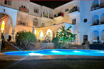 Piscina exterior iluminada por la noche en el hotel Residencia Miami de La Carihuela, Torremolinos.